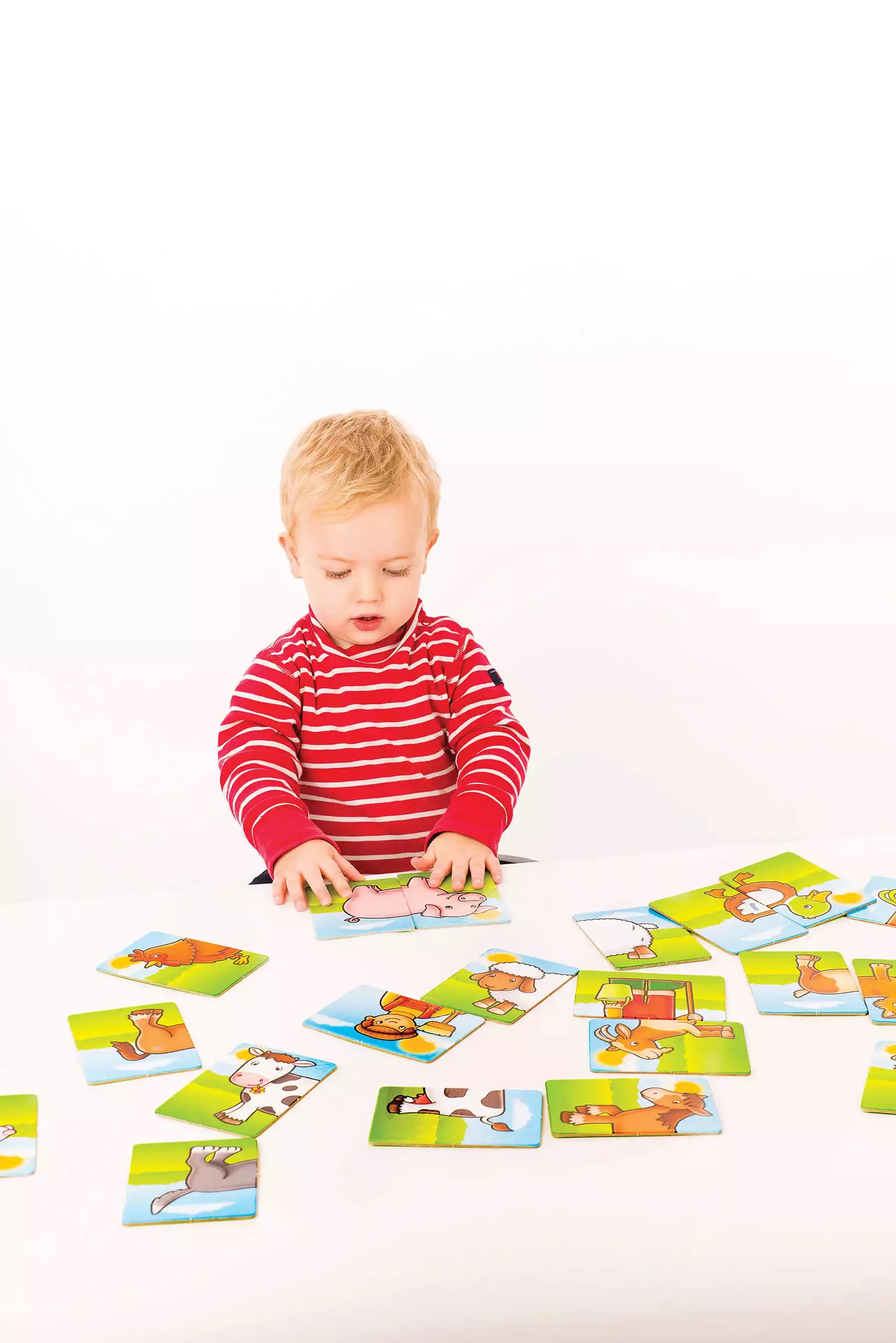 Kid playing with Farmyard Heads and Tails Matching Activity game 
