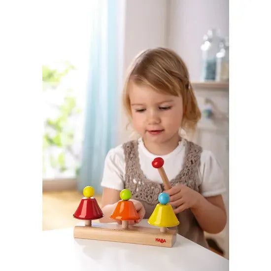 girl playing with HABA chimes musical toy - wooden playset
