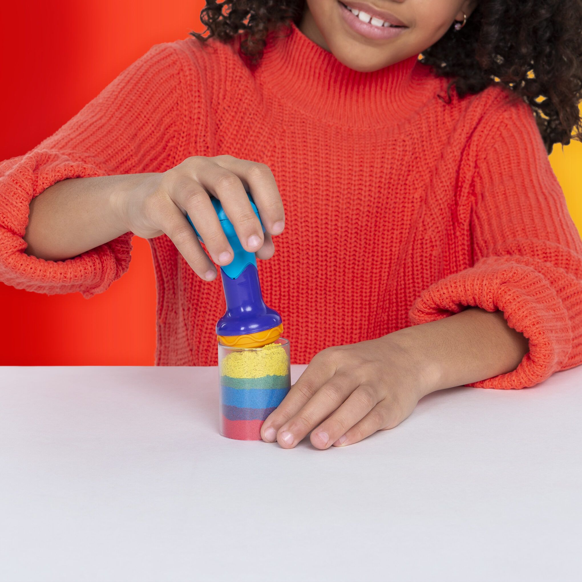 child enjoying creative activity with kinetic sand rainbow mix set from spin master
