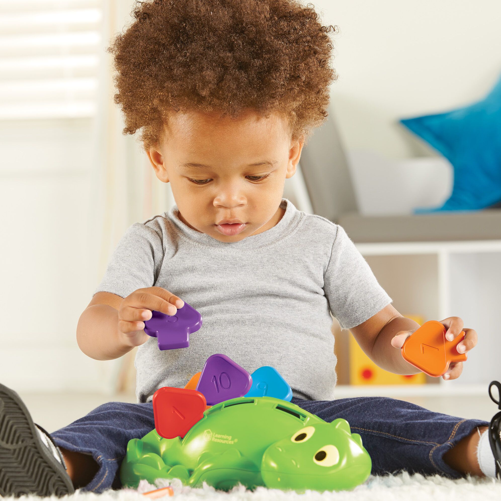 kid playing with steggy dino - learning resources toys
